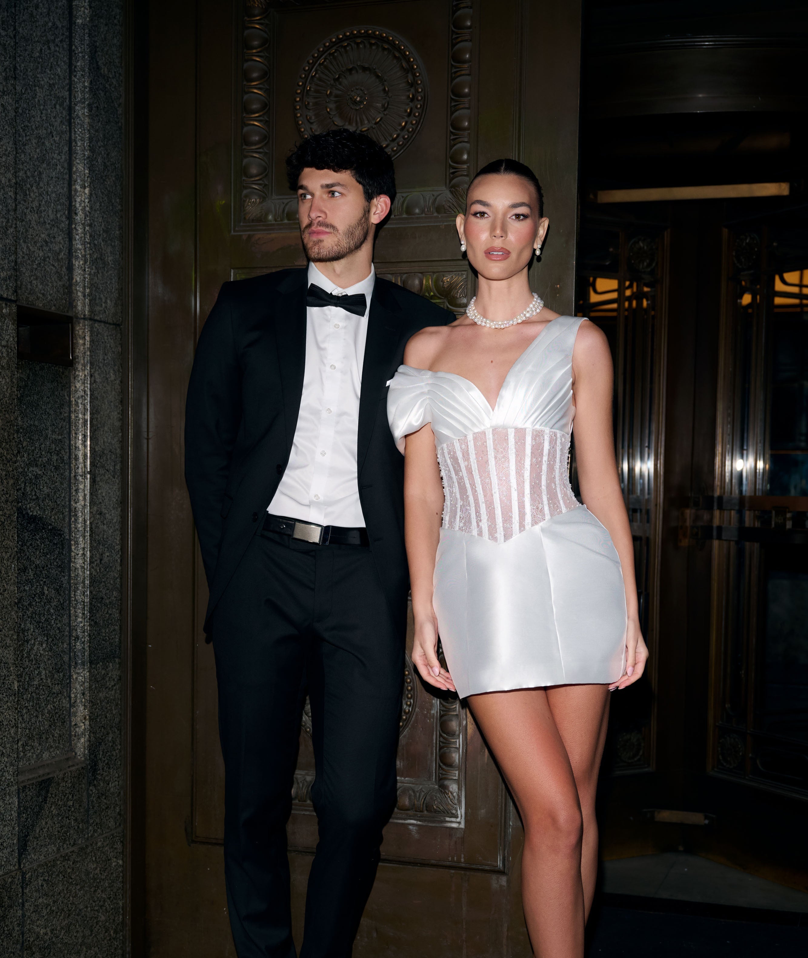Man and woman in formal attire standing on a staircase