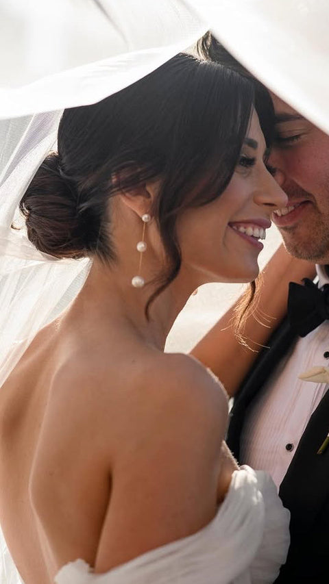 Wedding couple sharing a tender moment under an umbrella.