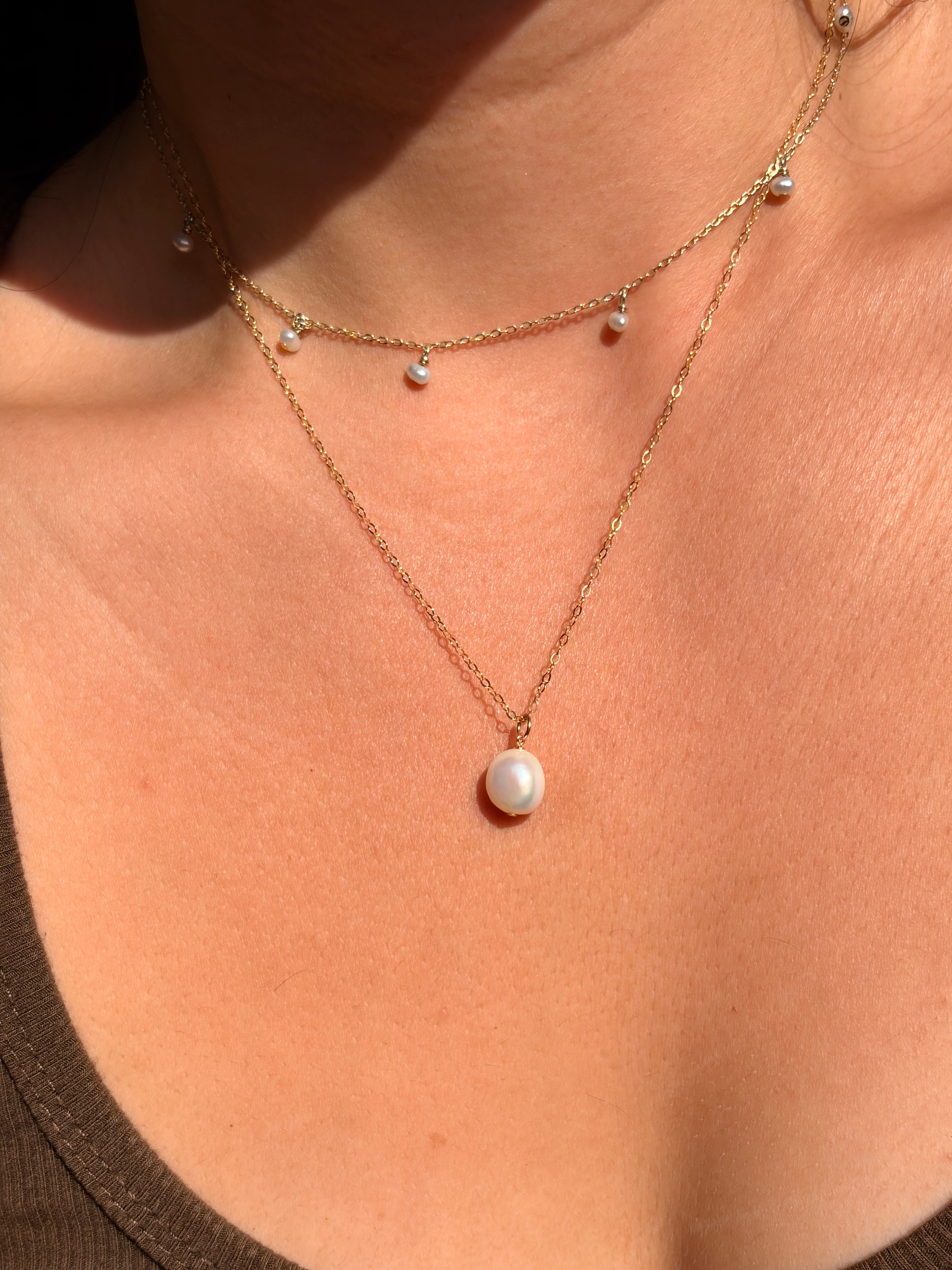 Gold chain with pearls on a person's skin